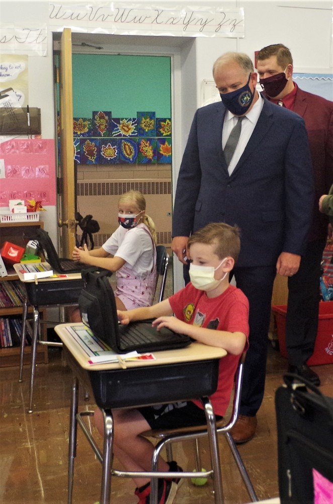 Assemblyman Bill Conrad watches a student at Riverview Elementary School work on a Chromebook. (Photo by Larry Austin/Tonawanda City School District
