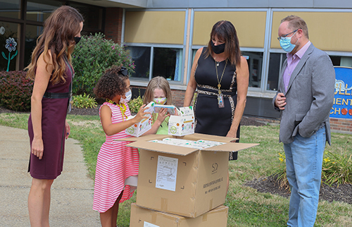 Students and officials with boxes of masks